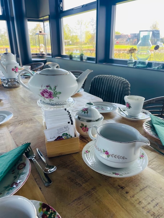 Bloemig servies en theepotten op een gedekte tafel